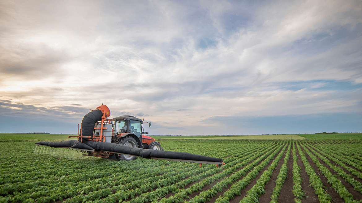 Nawozy dolistne - traktor rozpylający nawozy na polu